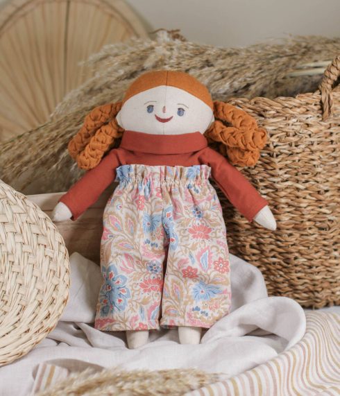 Blue-eyed Little Lenni doll Anna, with braided camel brown hair and dressed in a floral high waist trousers and terracotta turtleneck. Organic, natural materials. Handmade doll.