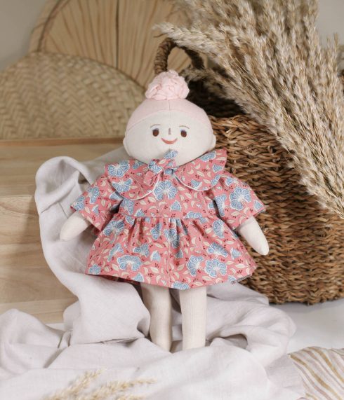 Little Lenni lutka Ema, sa ružičastom punđom, sjedi u cvjetnoj haljinici – ručna izrada, organski materijali.