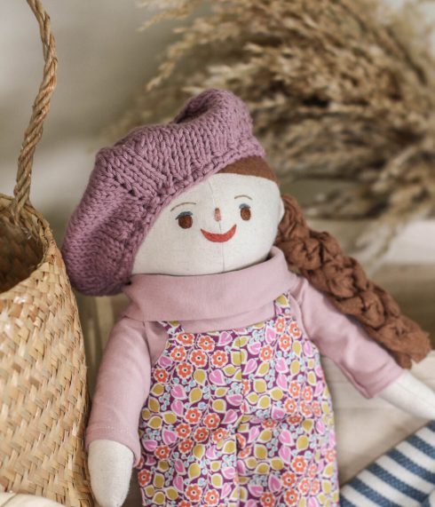 Little Lenni doll Lily, posing dressed up in pink tones floral clothes.